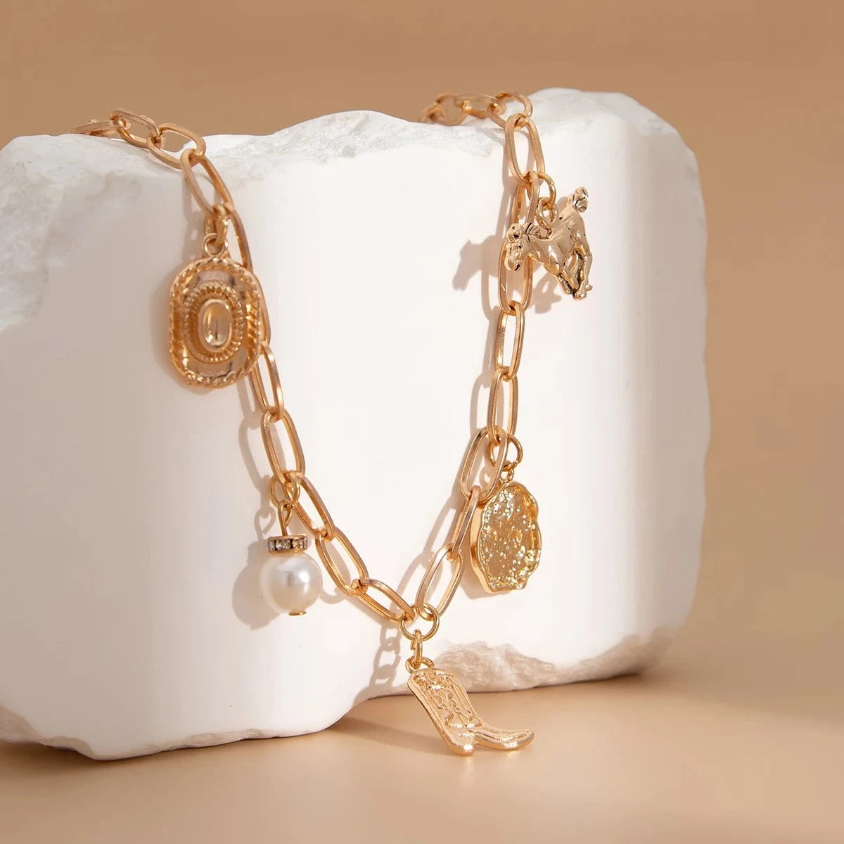 Chunky guldhalsband och armband med western-berlocker